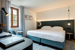 a hotel room with a bed and a desk at LUGANODANTE - We like you in Lugano