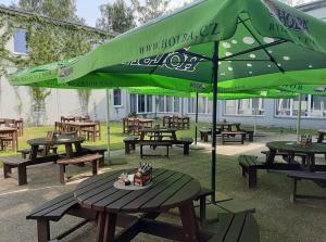 a group of picnic tables with a green umbrella at Sport Hotel Ticha Orlice in Ústí nad Orlicí