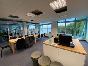een kantoor met tafels en stoelen en een laptop op een aanrecht bij Project Bay - Workation / CoWorking in Lietzow