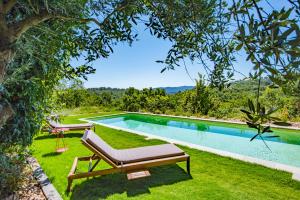 a swimming pool in a yard with a bench next to it at Location prestige 450 m2 dans Château en Provence in Brue-Auriac