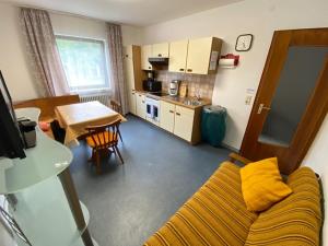 een woonkamer met een gele bank en een keuken bij Monteurswohnung Zimmerfrei Marktheidenfeld in Marktheidenfeld