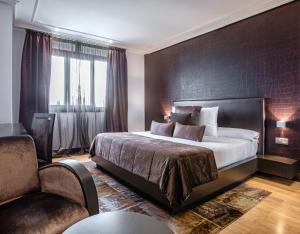 - une chambre avec un grand lit et une chaise dans l'établissement Hotel Pensua Punta del Este, à Carballo