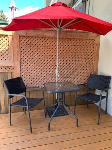 Le 154 Jacques-Cartier في غاسبيه: طاولة مع كرسيين ومظلة حمراء