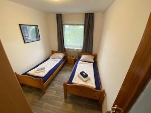 twee bedden in een kleine kamer met een raam bij Monteurswohnung Zimmerfrei Marktheidenfeld in Marktheidenfeld