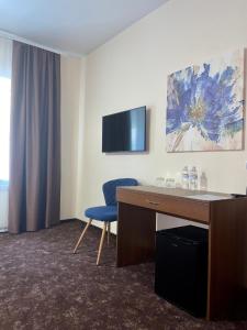 a hotel room with a desk and a blue chair at Forrest Park&Resort in Orlovshchina