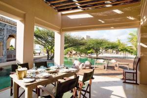 a dining room with a table and a view of the water at The Majlis Resort in Lamu