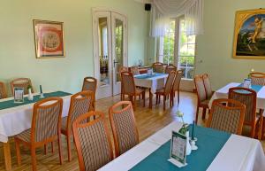 una sala da pranzo con tavoli e sedie in un ristorante di Hotel Waldhaus Prieros a Heidesee