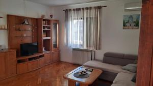 a living room with a couch and a table at Apartmani Krpeta in Pakoštane