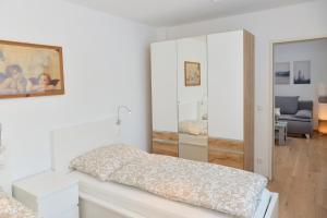 Habitación blanca con cama y espejo en Apartment Olperer en Mühlbachl