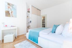 a white bedroom with a bed and a mirror at Sun Spalato City in Split