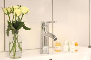 a bathroom sink with a vase with yellow roses in it at Ferienwohnung Sophia's 4.0 in Brilon