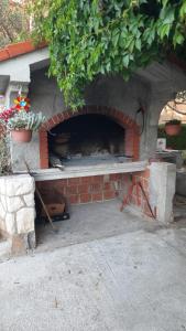 een bakstenen oven met een tafel ervoor bij Apartmani Krpeta in Pakoštane