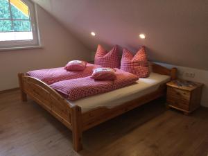 ein Schlafzimmer mit einem Bett mit rosa Kissen darauf in der Unterkunft Ferienhaus Gasthof Kanzlersgrund in Oberhof