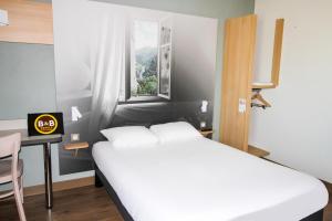 Tempat tidur dalam kamar di B&B HOTEL Valence TGV Romans