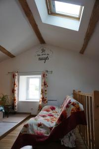 - une chambre avec un lit dans une pièce dotée d'une fenêtre dans l'établissement Maison Entre Terre Et Pierre, proche Nantes aéroport, à Bouguenais