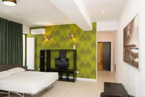 a bedroom with a bed and a green wall at Green Lake Apartment 5 in Mamaia