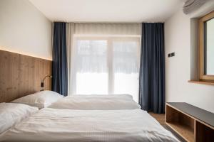 - une chambre avec deux lits en face d'une fenêtre dans l'établissement App. Col Toronn - Ciasa Lavarella, à San Vigilio Di Marebbe