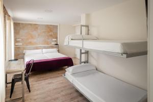 a room with two bunk beds and a table and a chair at YIT Casablanca in Granada