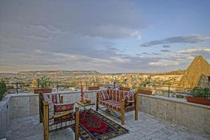 a balcony with chairs and a view of the pyramids at Cappadocia Cave Lodge in Goreme