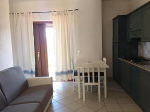 - un salon avec un canapé et une table dans l'établissement Vallemare Residence e Studios, à Baja Sardinia