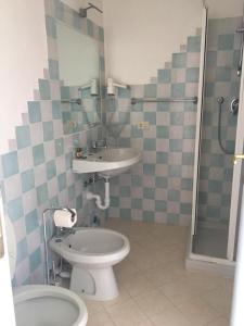 a bathroom with a toilet and a sink and a shower at Vallemare Residence e Studios in Baja Sardinia