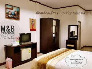 ein Schlafzimmer mit einem Bett und einem TV in einem Zimmer in der Unterkunft M&B in Ban Dung