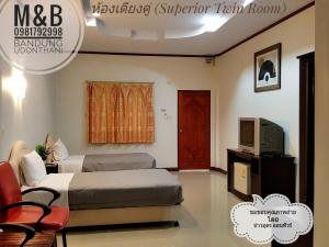 a bedroom with a bed and a television in it at M&B in Ban Dung