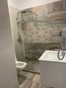 a bathroom with a toilet and a glass shower at Apartament Alexandra in Mamaia +8 photos