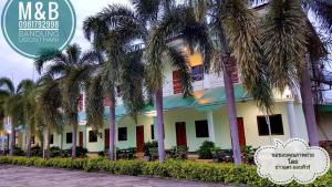 a building with palm trees in front of it at M&B in Ban Dung
