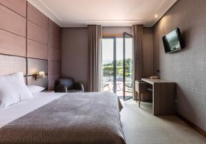 a hotel room with a bed and a television at Hotel Pensua Punta del Este in Carballo