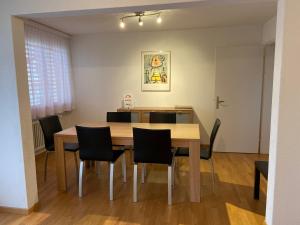 een eetkamer met een houten tafel en stoelen bij Serviced Apartments Haus 2 in Uzwil