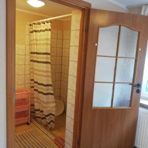 a door leading to a bathroom with a shower at DOM SABINA in Krynica Morska