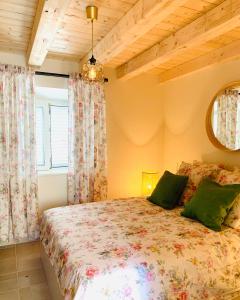 1 dormitorio con 1 cama con almohadas verdes en La Casetta di Gloria, en Lumbarda