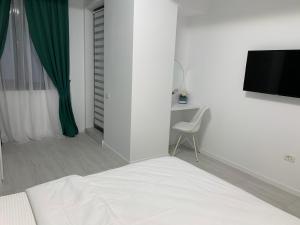 a bedroom with a bed and a desk and a television at Apartament Alexandra in Mamaia