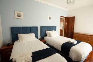 パレーデにあるMeriteluna Beach - Lisboa, Sintra e Cascaisの白と青の部屋のベッド2台