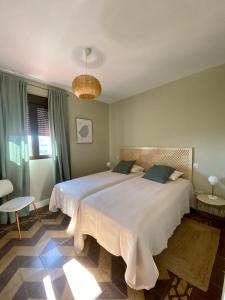 1 dormitorio con 2 camas y lámpara de araña en Galería de Cervantes en Toledo