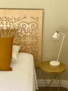 a bedroom with a bed and a table with a lamp at Galería de Cervantes in Toledo