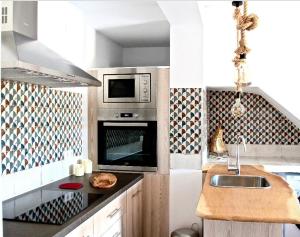 a kitchen with a sink and a microwave at Al Lago in Zahara de la Sierra