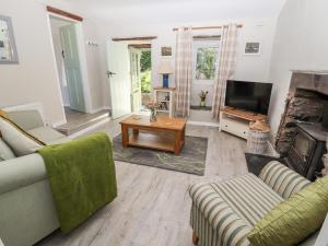 a living room with a couch and a tv at Ysgubor Ucha in Ruthin