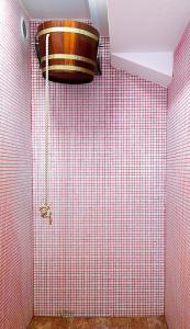 uma casa de banho com uma parede de azulejos vermelhos e um balde em Hotel Rusu em Petroşani