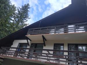 a house with a black roof and a balcony at Pensjonat Syriusz in Karpacz