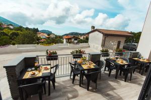 un patio con mesas y sillas en el balcón en Acqua Leggia, en Agerola