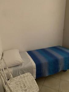 a small bedroom with a bed and a chair at Da Nonna Laura al Circeo in San Felice Circeo +1 photo