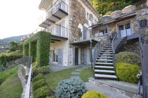 - un bâtiment en pierre avec des escaliers et du lierre dans l'établissement Casa di campagna Rosina con piscina e vista lago, à Gravedona