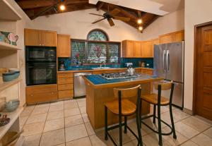 a kitchen with a center island with two bar stools at BELLAMARE in Virgin Gorda