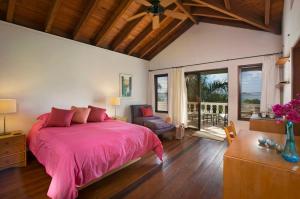 a bedroom with a pink bed and a large window at BELLAMARE in Virgin Gorda