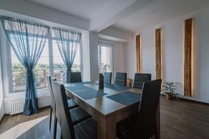 a dining room with a table and chairs and a large window at Sunset Inn in Sîngeorgiu de Mureş