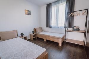 um quarto com uma cama, um banco e uma janela em Sunset Inn em Sîngeorgiu de Mureş