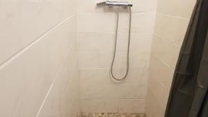 a shower with a hose in a bathroom at Cosy F2 proche de DisneyLand Paris in Meaux