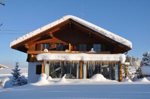una casa ricoperta di neve con sopra dei ghiaccioli di Landhaus Brigitte a Obermaiselstein